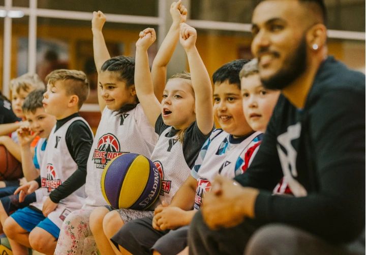 Young basketball players cheering on the bench