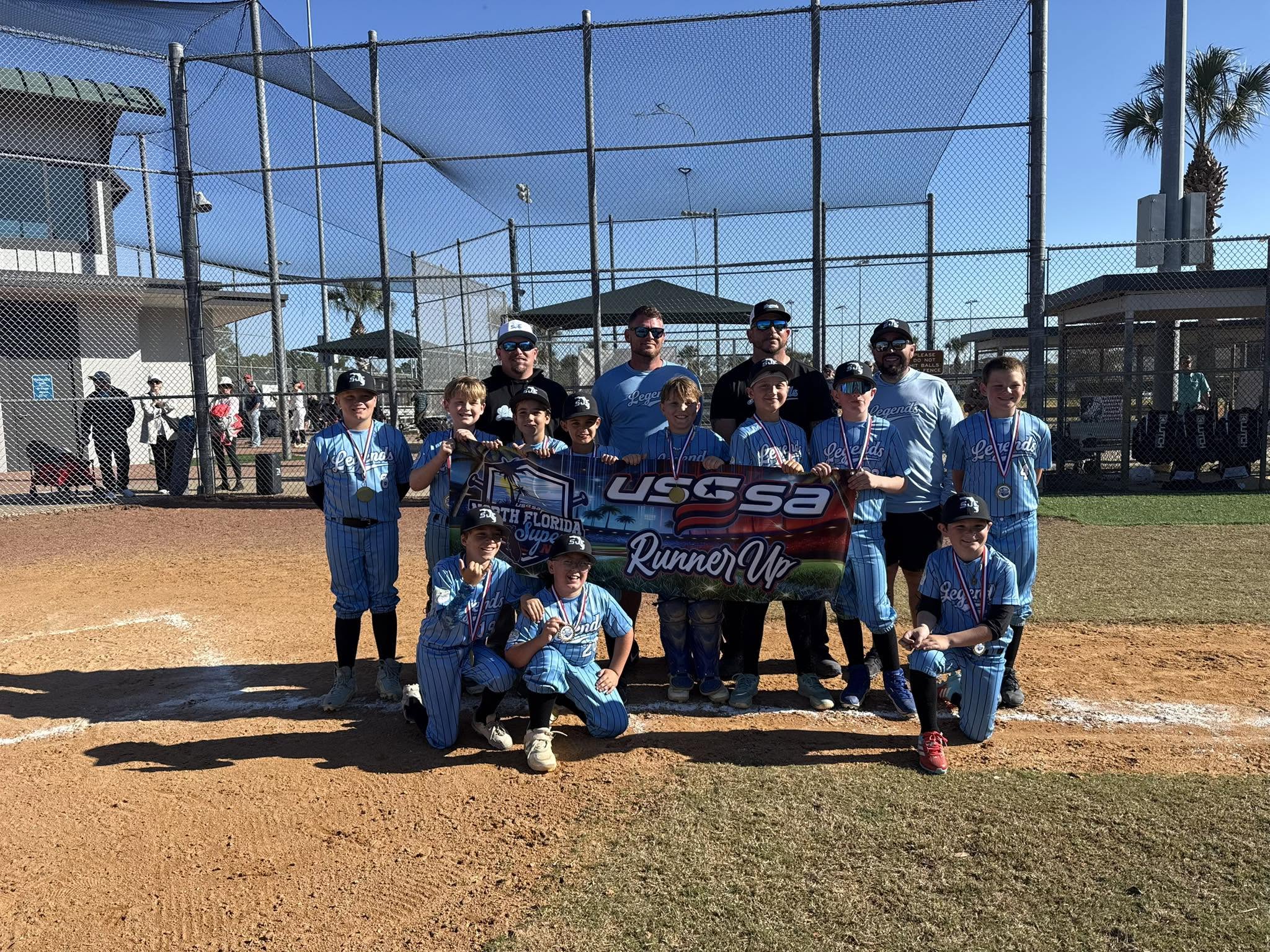 SJC Legends 11U holding the USSSA Runner-Up banner at the field